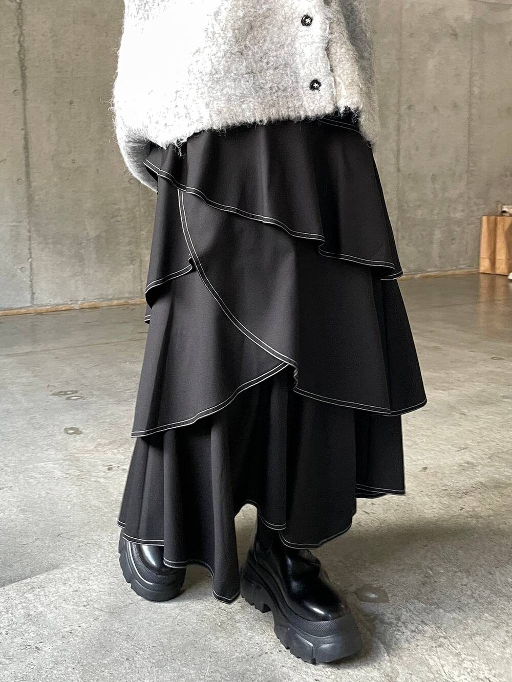 ホワイト系のキャミソール、ブラック系のブーツ、ホワイト系のクラッチバッグを着用したレディースの冬コーディネートの4枚目の写真