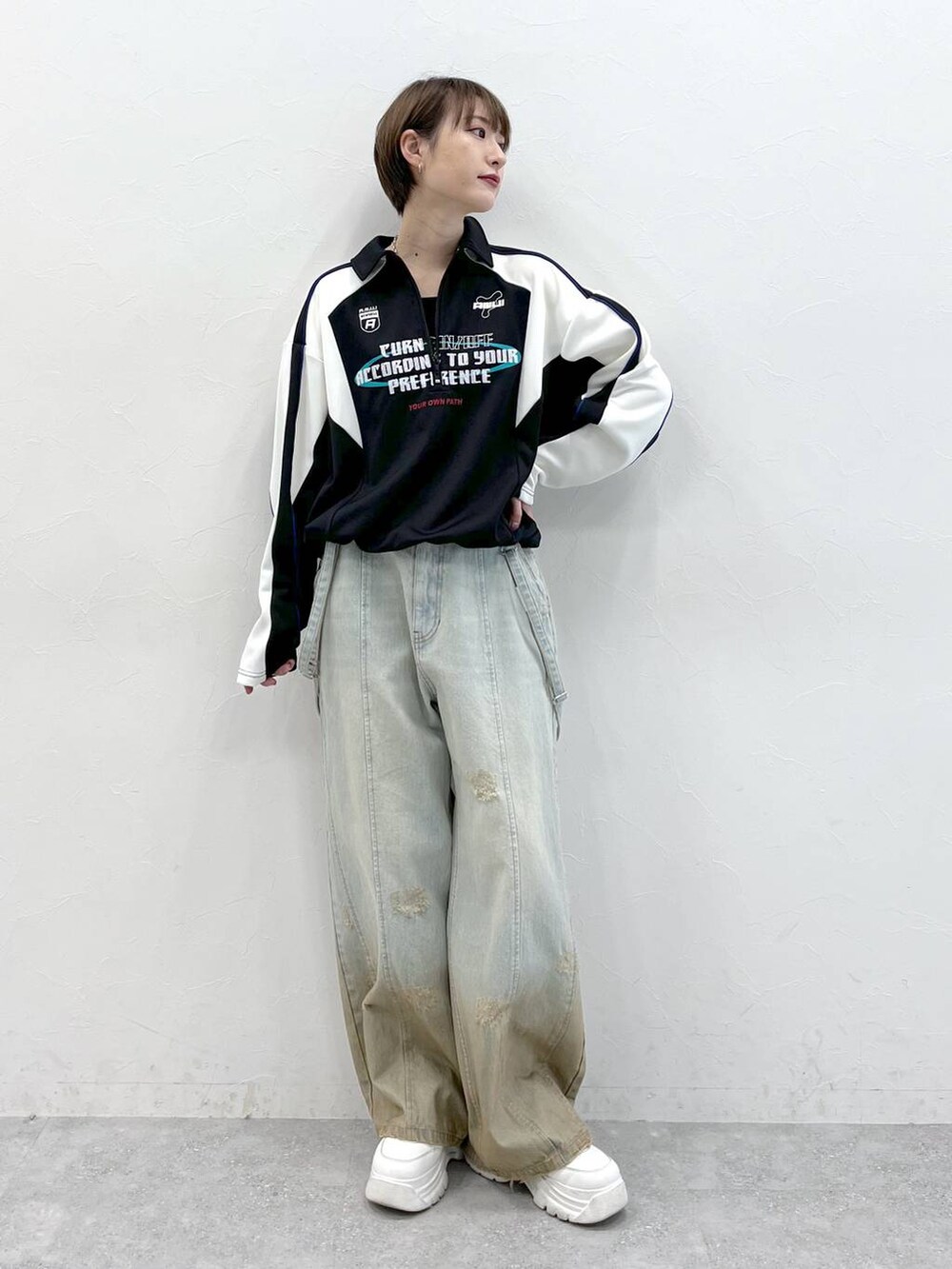 ブラック系のポロシャツ、ブルー系のデニムパンツを着用したレディースの春コーディネートの2枚目の写真