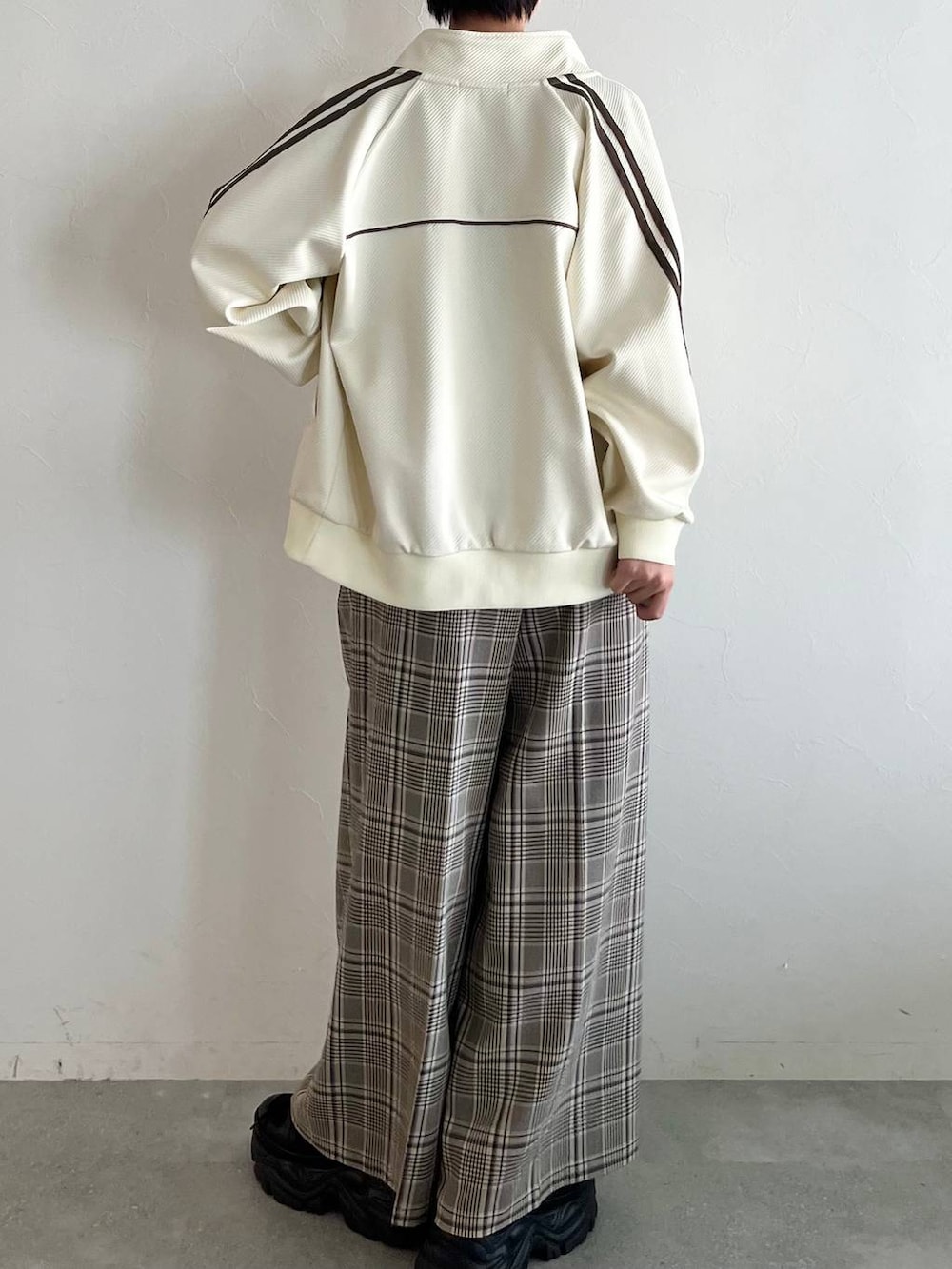 ブラック系のスニーカー、ベージュ系のスラックス、ホワイト系のジャージを着用したレディースの秋コーディネートの7枚目の写真