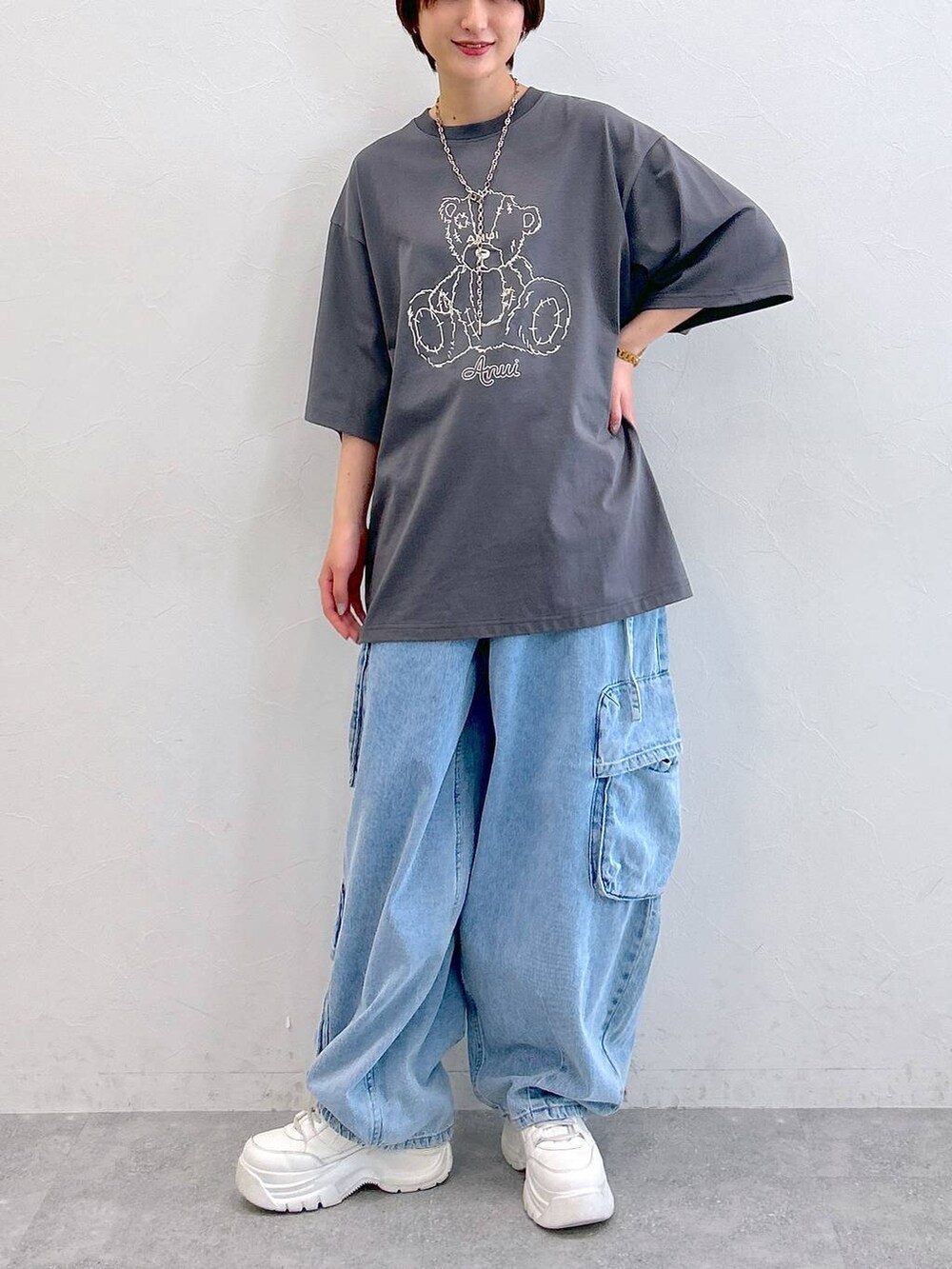 グレー系のTシャツ/カットソー、ブルー系のデニムパンツ、シルバー系のネックレスを着用したレディースの夏コーディネートの2枚目の写真