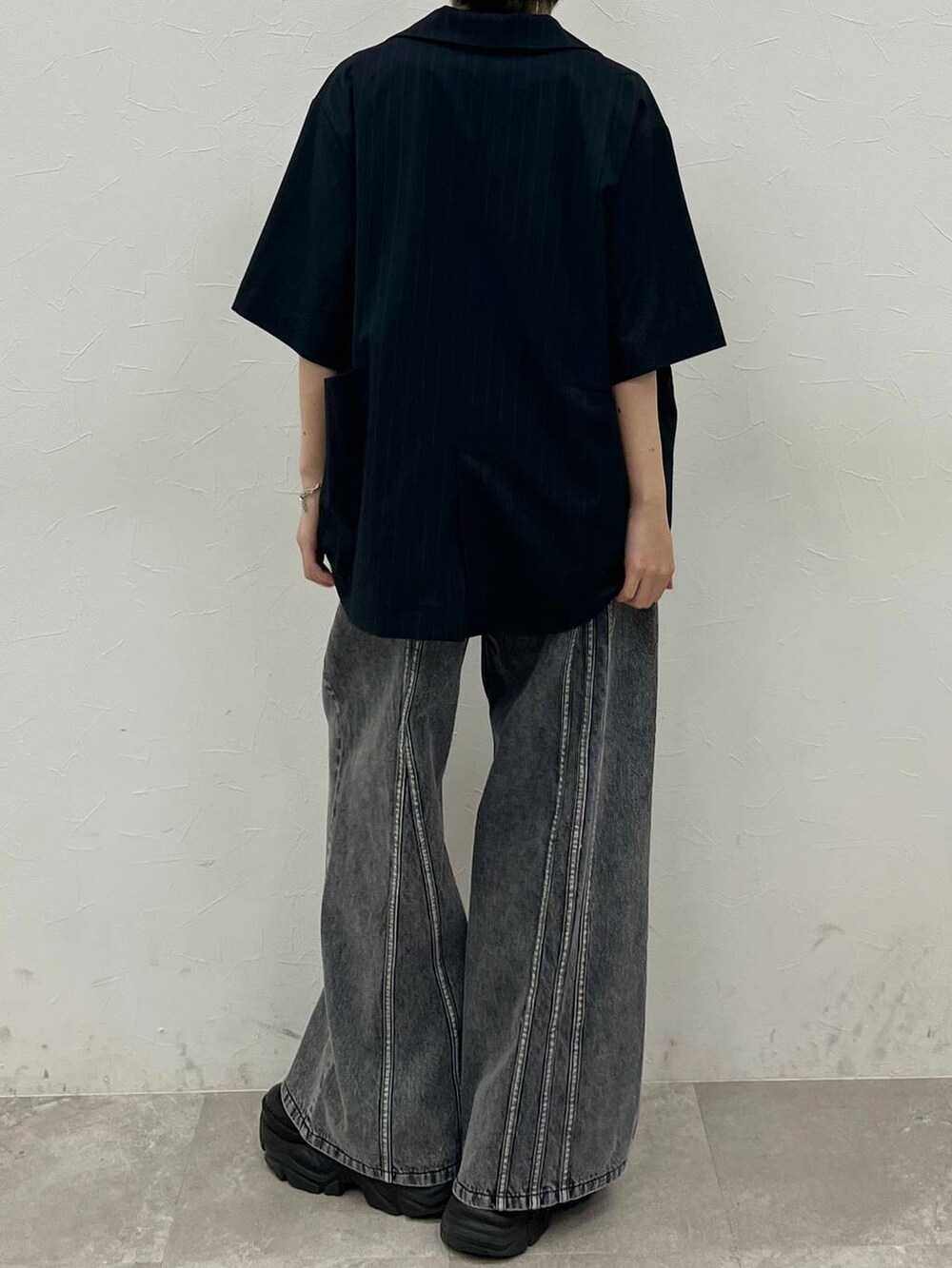 ブラック系のスニーカー、ブルー系のTシャツ/カットソー、ブラック系のデニムパンツを着用したレディースの春コーディネートの7枚目の写真