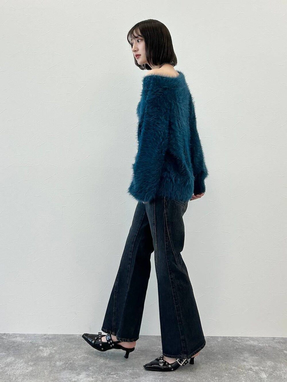 ブルー系のデニムパンツ、ブラック系のパンプス、ブルー系のニット/セーターを着用したレディースの秋コーディネートの3枚目の写真