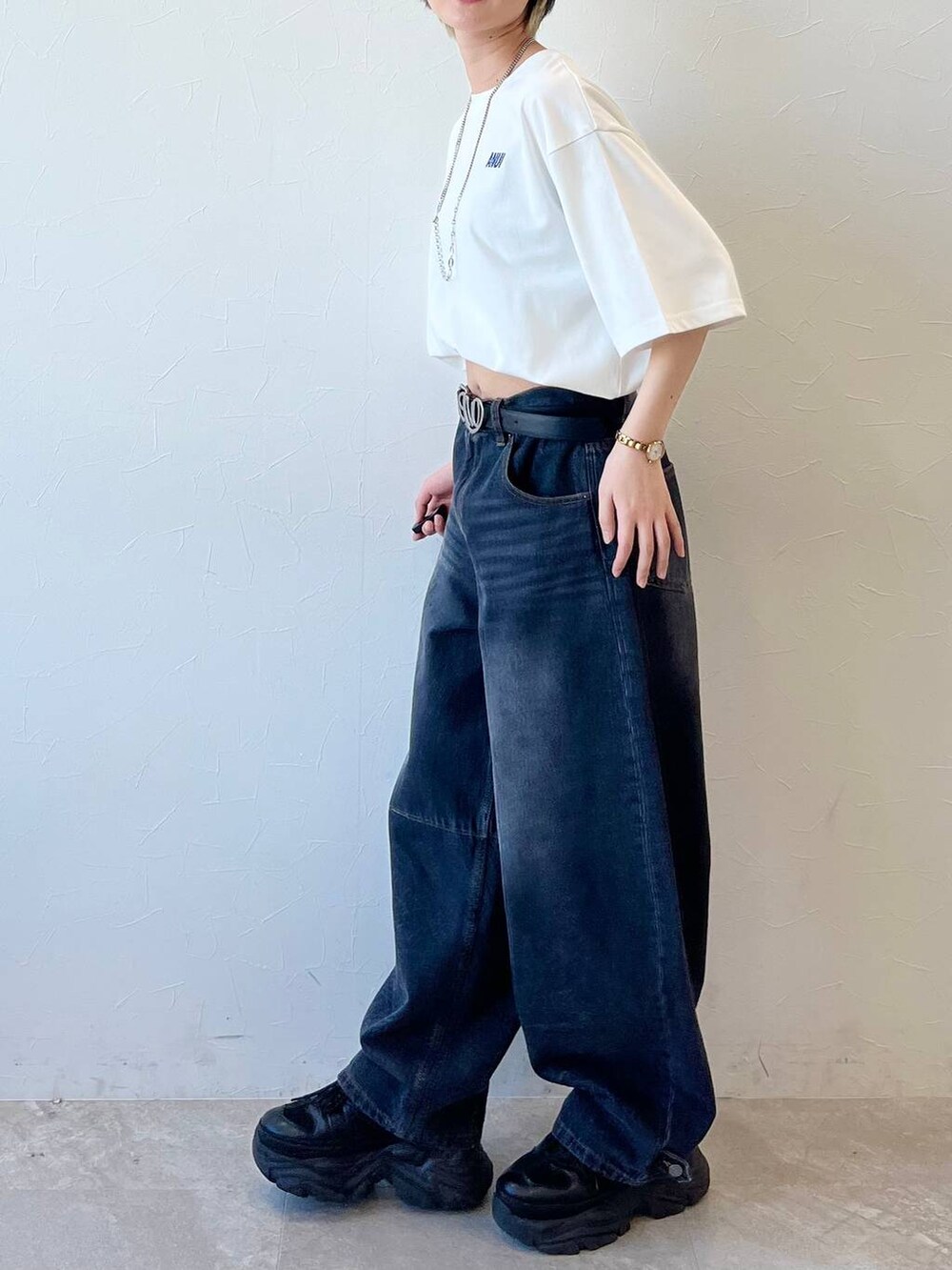 ブラック系のスニーカー、ブラック系のデニムパンツ、ホワイト系のTシャツ/カットソーを着用したレディースの春コーディネートの8枚目の写真