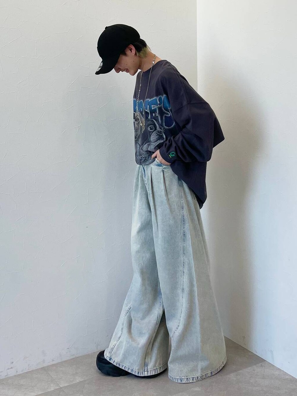 ブラック系のスニーカー、ブルー系のデニムパンツ、ブラック系のキャップを着用したレディースの春コーディネートの5枚目の写真