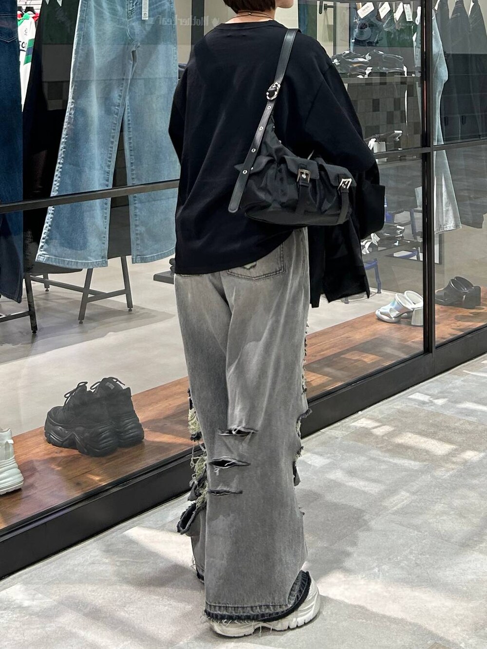 ブラック系のショルダーバッグ、ブラック系のテーラードジャケット、ブラック系のデニムパンツを着用したレディースの春コーディネートの5枚目の写真