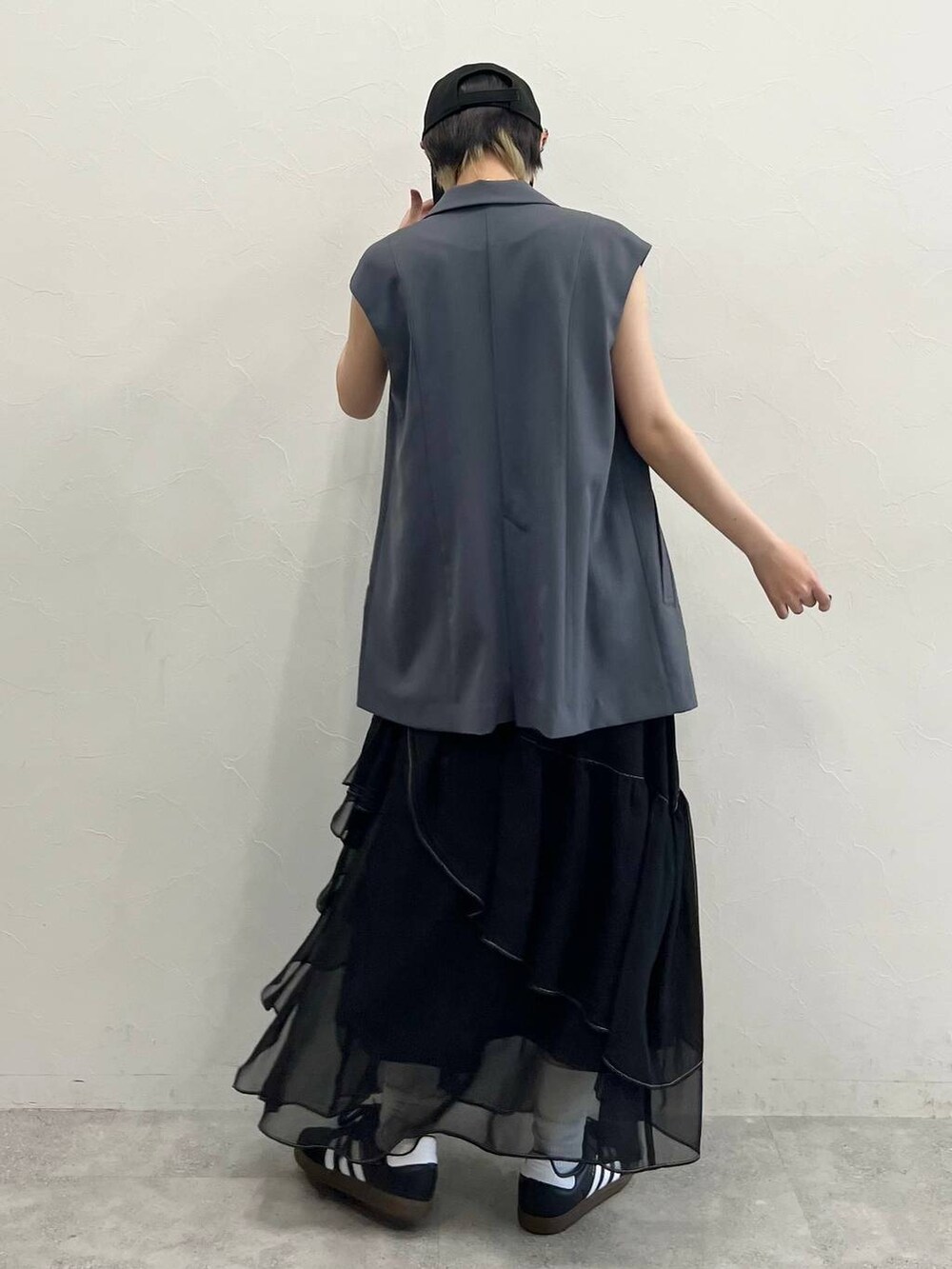 ブラック系のスカート、ブラック系のスニーカー、ブラック系のキャミソールを着用したレディースの春コーディネートの6枚目の写真