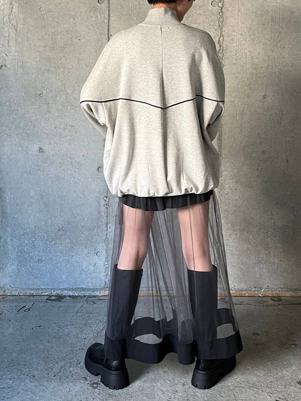 ブラック系のブーツ、グレー系のスウェット、グレー系のスカートを着用したレディースの冬コーディネートの7枚目の写真