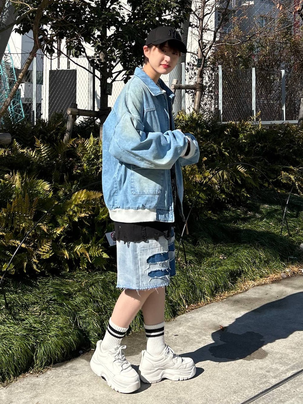 ブルー系のデニムジャケット、ブルー系のデニムパンツ、ブラック系のカーディガン/ボレロを着用したレディースの春コーディネートの4枚目の写真