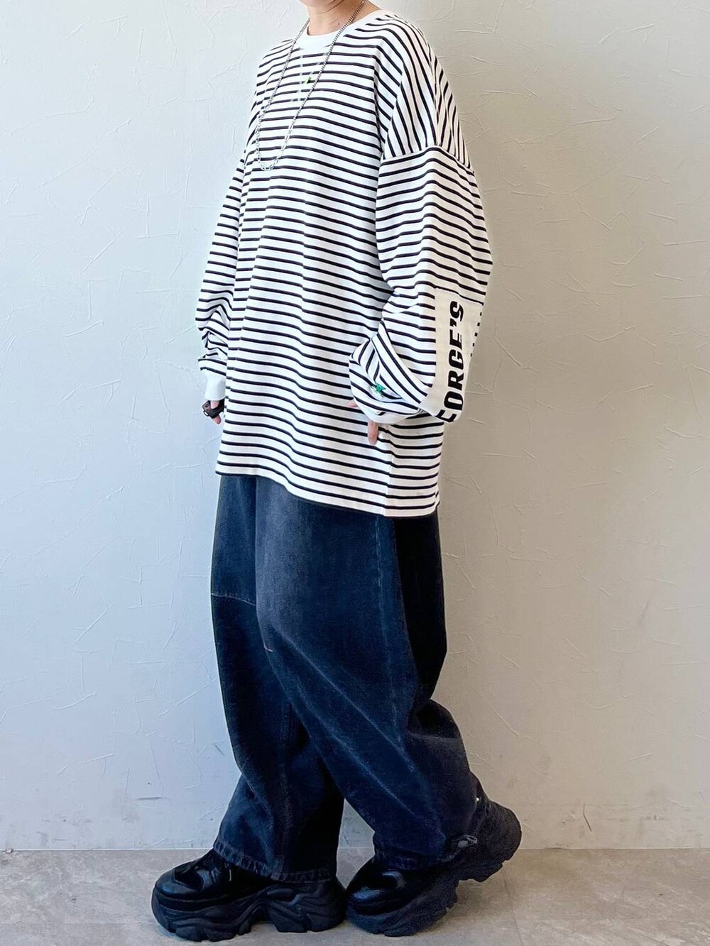 ブラック系のスニーカー、ブラック系のデニムパンツ、ブラック系のキャップを着用したレディースの春コーディネートの5枚目の写真