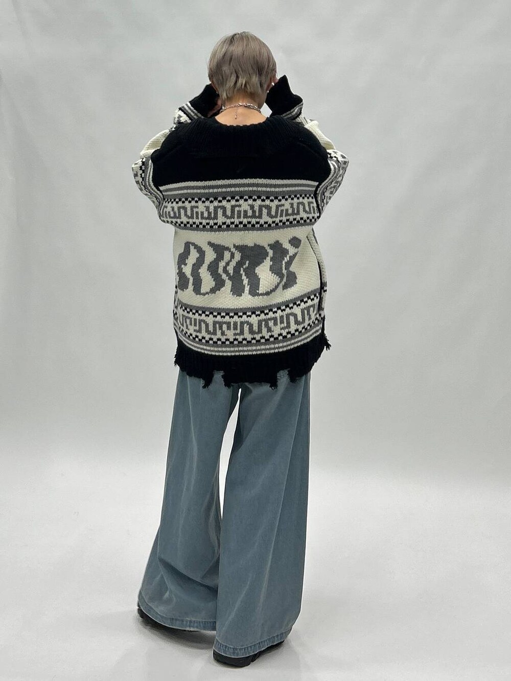 ブルー系のデニムパンツ、ブラック系のブーツ、ブラック系のスウェットを着用したレディースの秋コーディネートの5枚目の写真