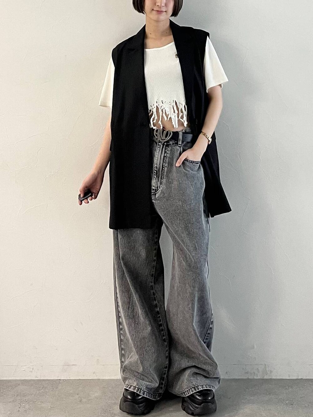 ブラック系のスニーカー、ブラック系のデニムパンツ、ブラック系のその他アウターを着用したレディースの春コーディネートの9枚目の写真