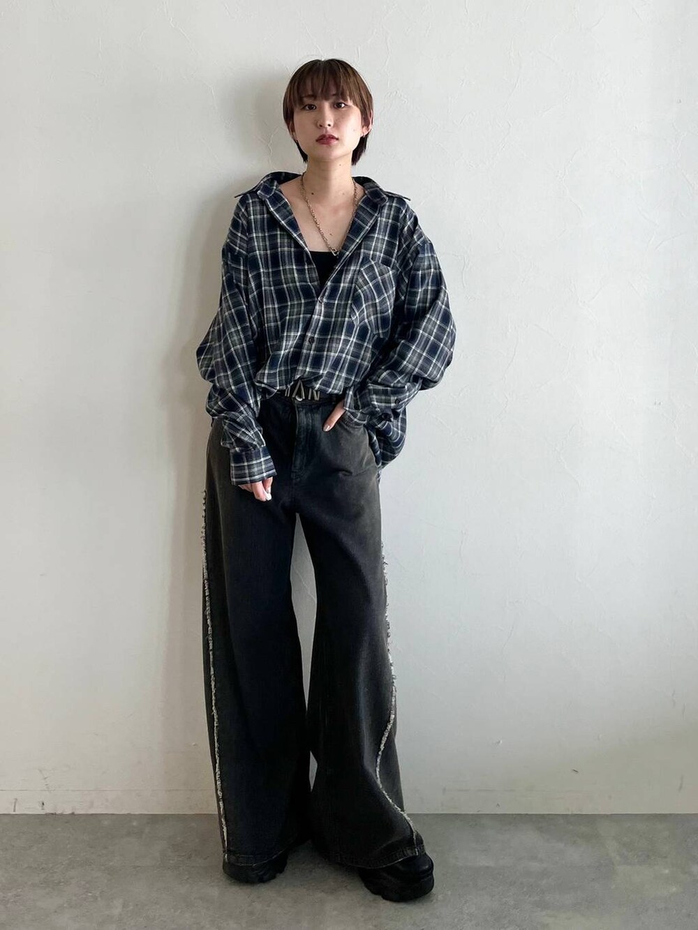 ブラック系のスニーカー、ブルー系のシャツ/ブラウス、ブラック系のデニムパンツを着用したレディースの秋コーディネートの2枚目の写真