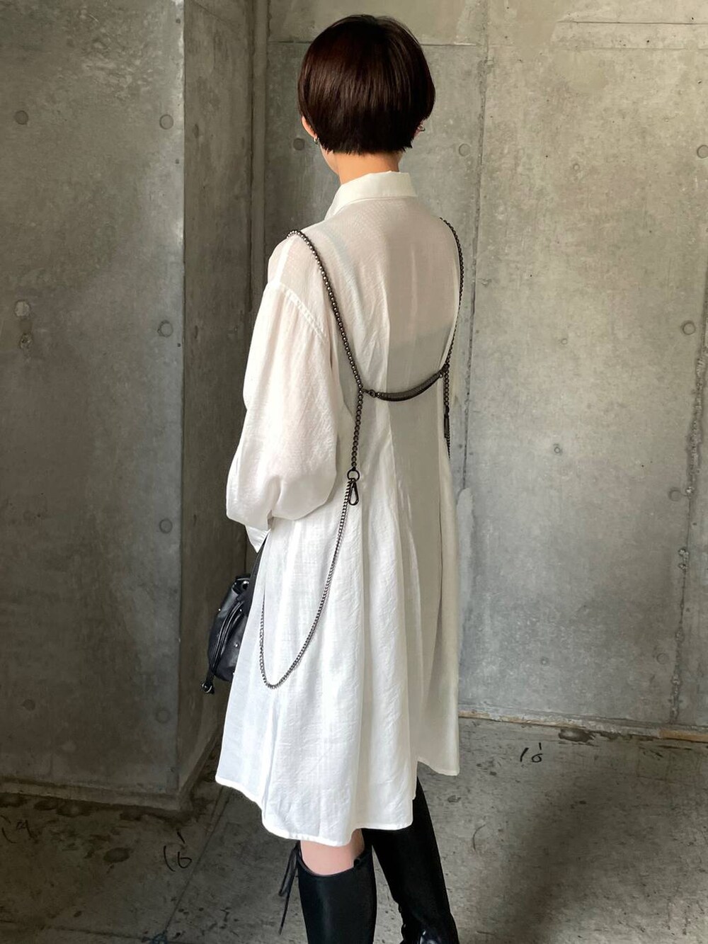 ブラック系のブーツ、ブラック系のショルダーバッグ、ホワイト系のシャツ/ブラウスを着用したレディースの秋コーディネートの3枚目の写真