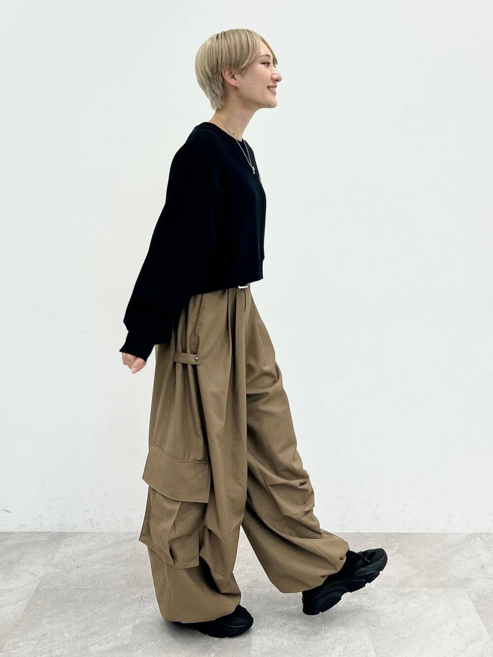 ブラック系のスウェット、ベージュ系のカーゴパンツ、シルバー系のネックレスを着用したレディースの秋コーディネートの6枚目の写真