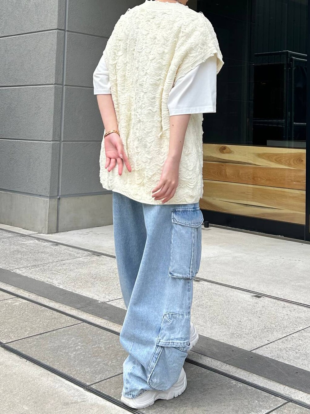 ホワイト系のベスト、ホワイト系のTシャツ/カットソー、ブルー系のデニムパンツを着用したレディースの夏コーディネートの8枚目の写真