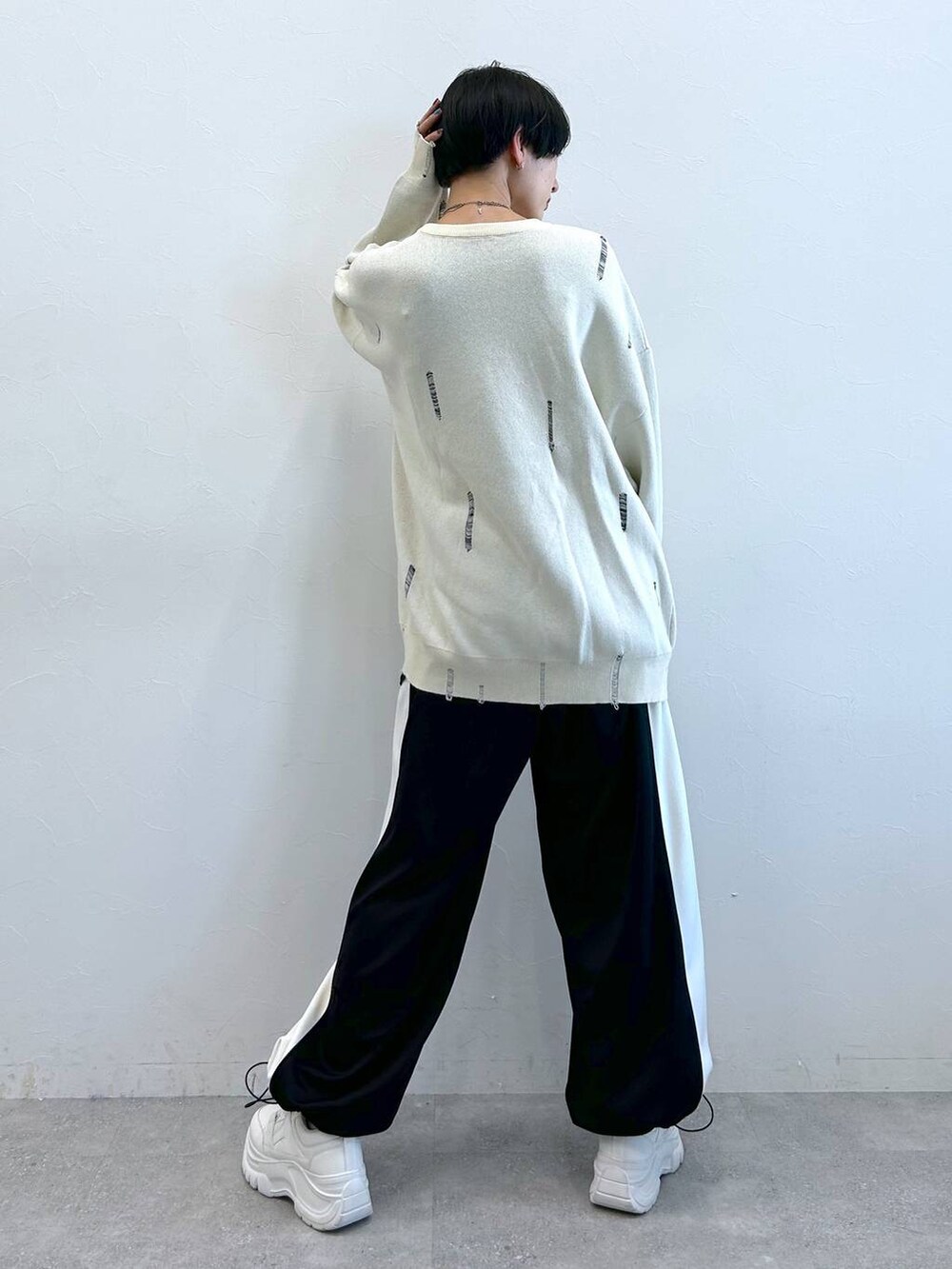 ブラック系のその他パンツ、ホワイト系のニット/セーターを着用したレディースの秋コーディネートの6枚目の写真