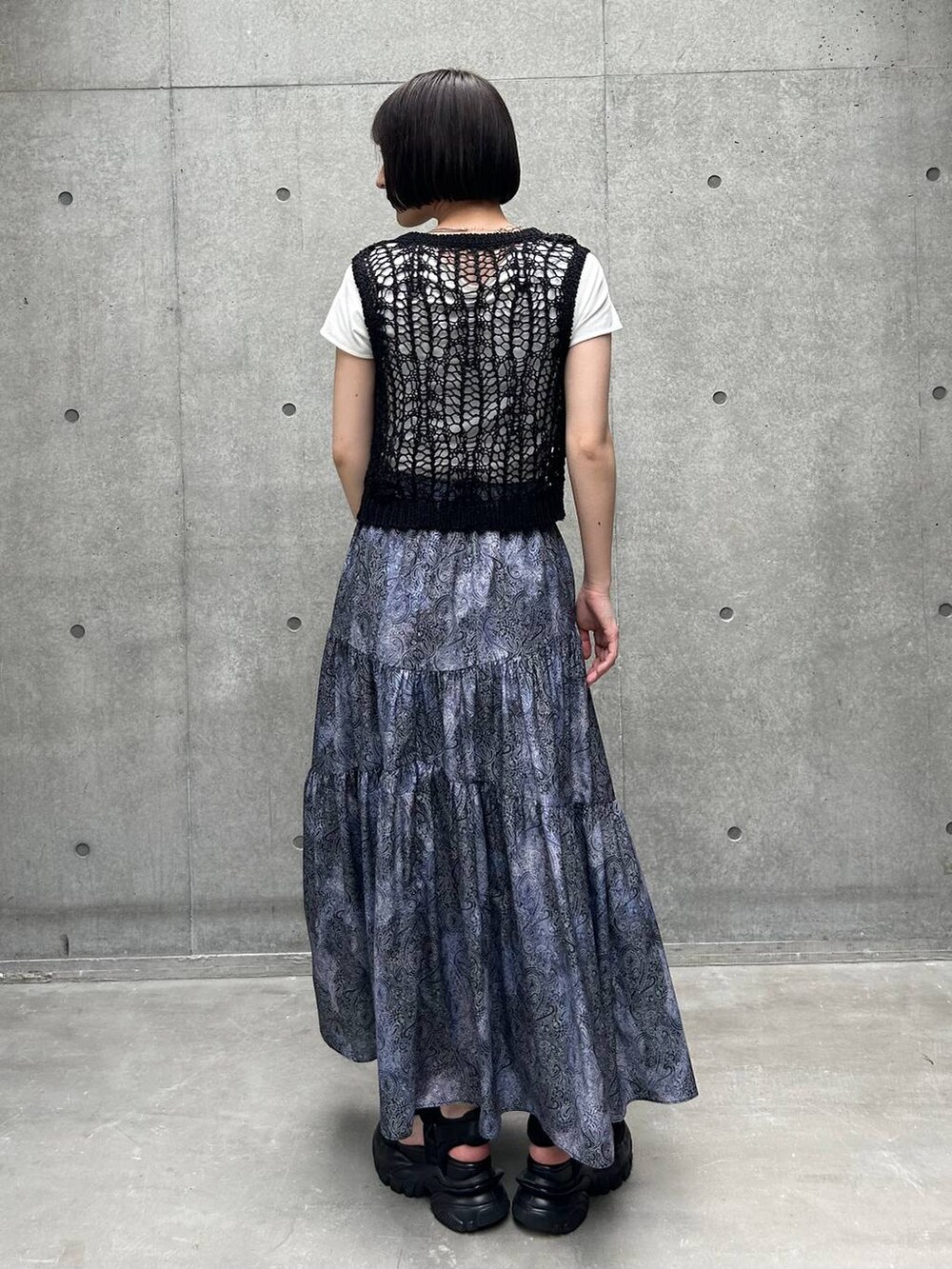 ブラック系のサンダル、ホワイト系のTシャツ/カットソー、ブラック系のスカートを着用したレディースの夏コーディネートの5枚目の写真