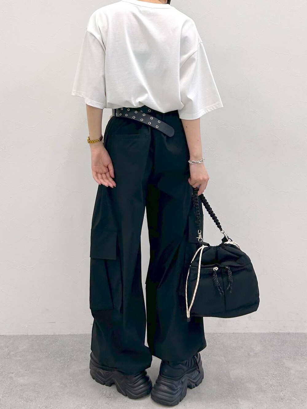 ブラック系のスニーカー、ホワイト系のTシャツ/カットソー、ブラック系のショルダーバッグを着用したレディースの夏コーディネートの8枚目の写真