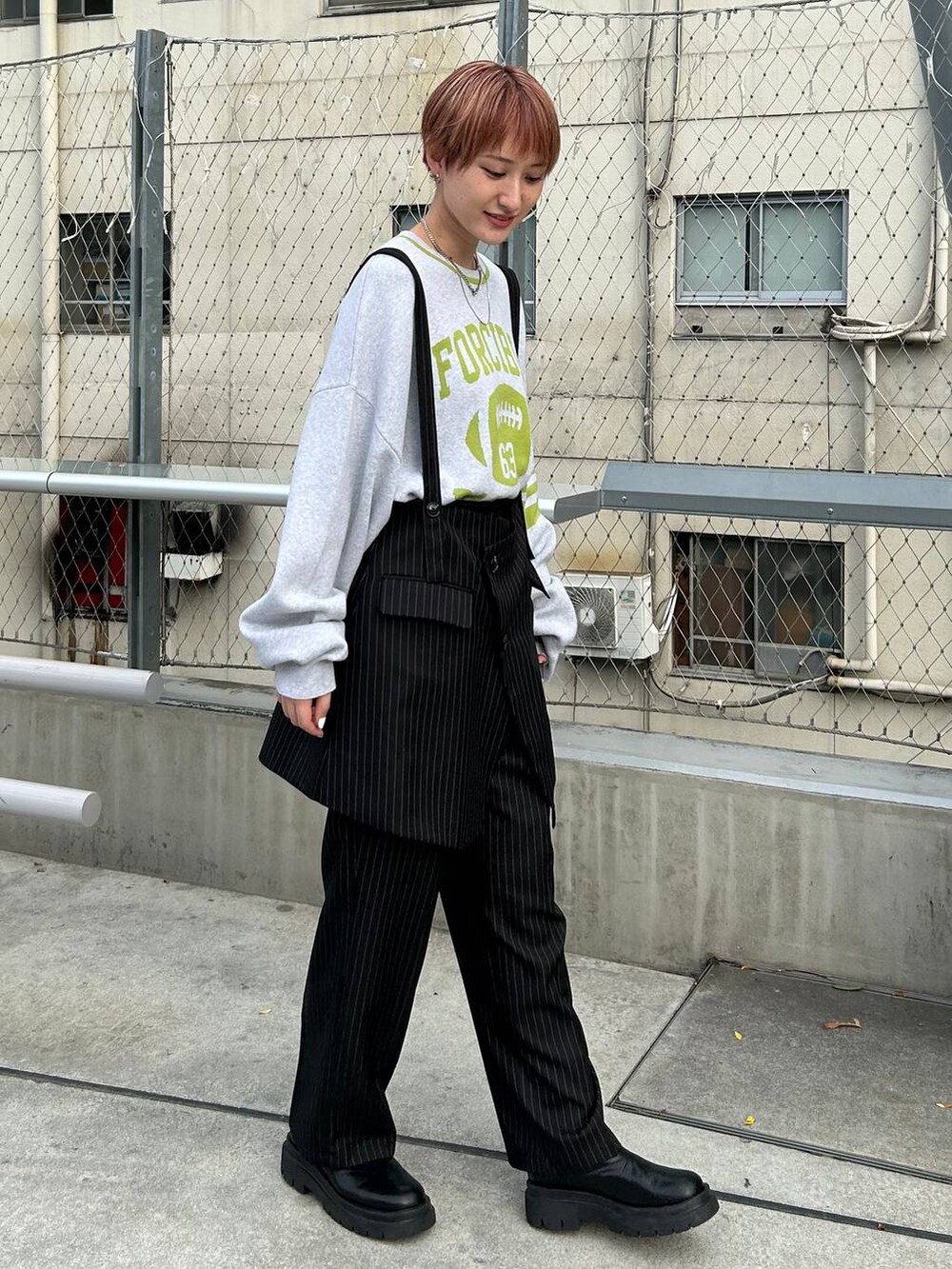 ブラック系のスラックス、ベージュ系のニット/セーターを着用したレディースの秋コーディネートの3枚目の写真