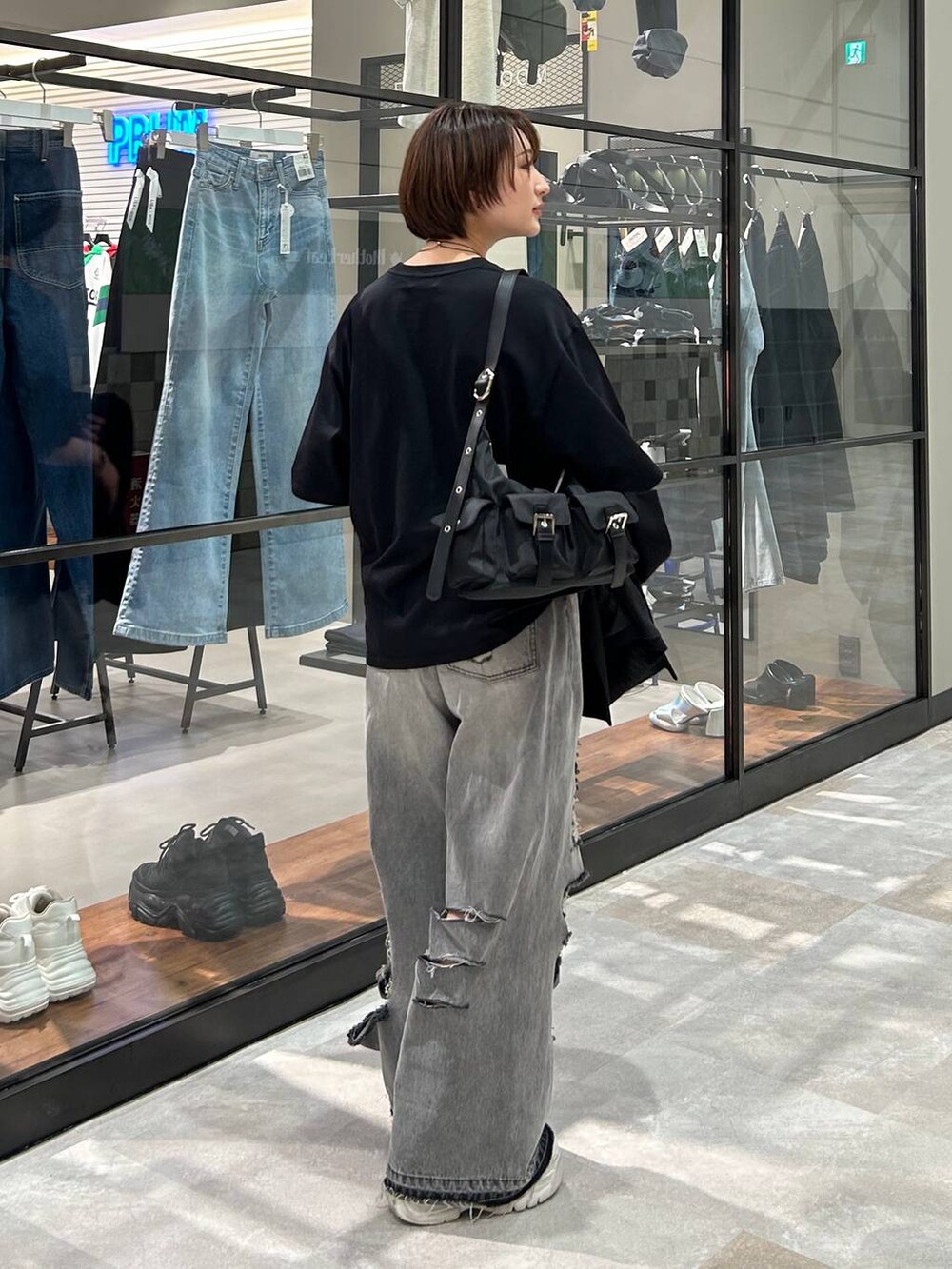 ブラック系のショルダーバッグ、ブラック系のテーラードジャケット、ブラック系のデニムパンツを着用したレディースの春コーディネートの6枚目の写真