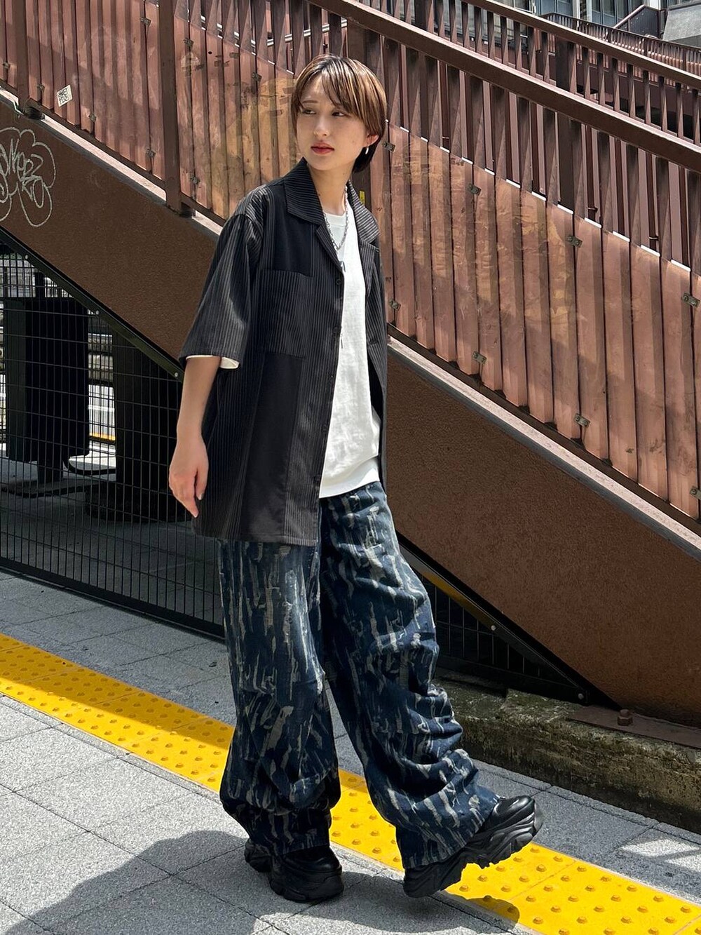 ブラック系のスニーカー、ホワイト系のTシャツ/カットソー、ブラック系のシャツ/ブラウスを着用したレディースの秋コーディネートの8枚目の写真