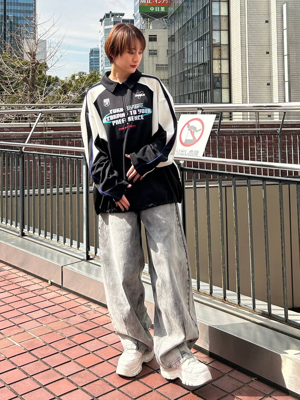 ブラック系のポロシャツ、ブラック系のデニムパンツを着用したレディースの春コーディネートの2枚目の写真