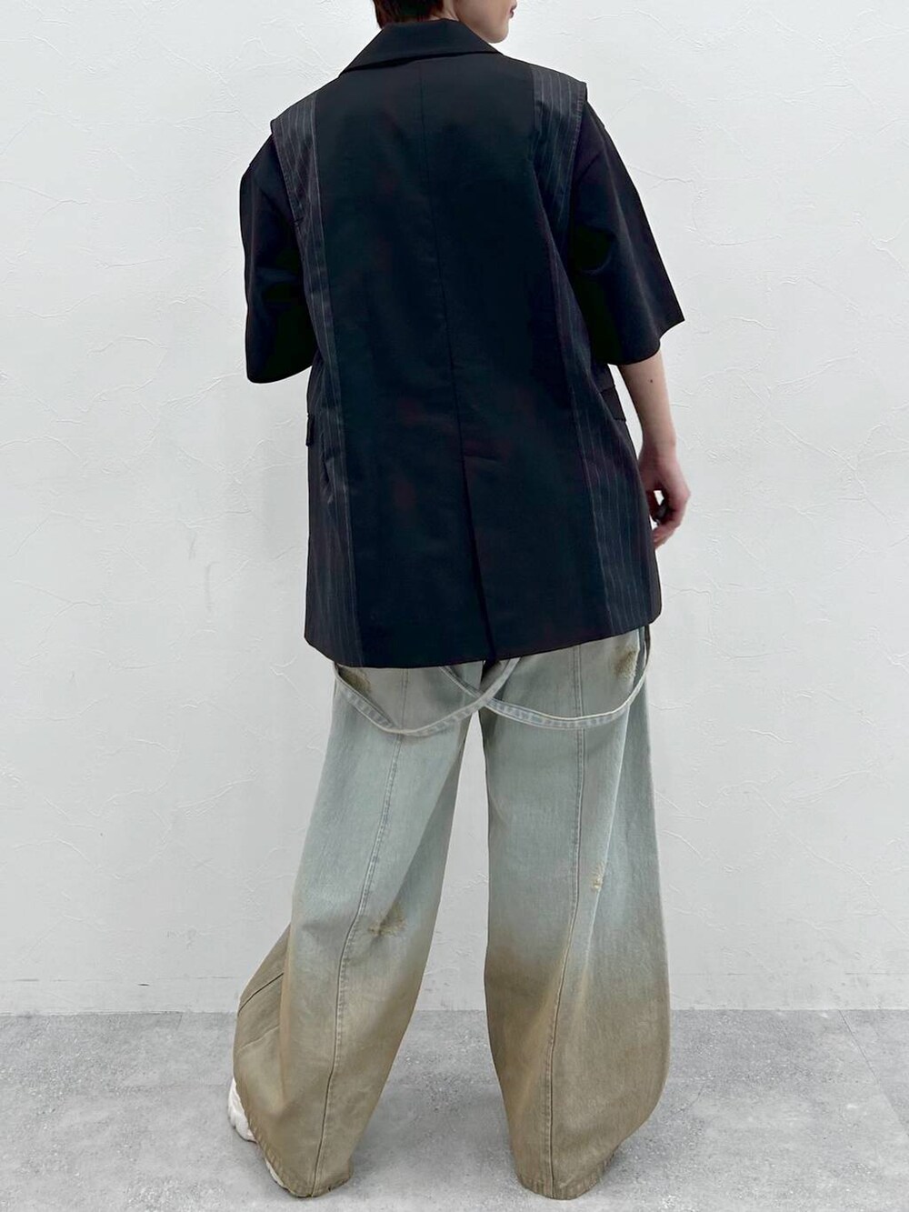 ブラック系のTシャツ/カットソー、ブルー系のデニムパンツ、ブラック系のテーラードジャケットを着用したレディースの春コーディネートの4枚目の写真