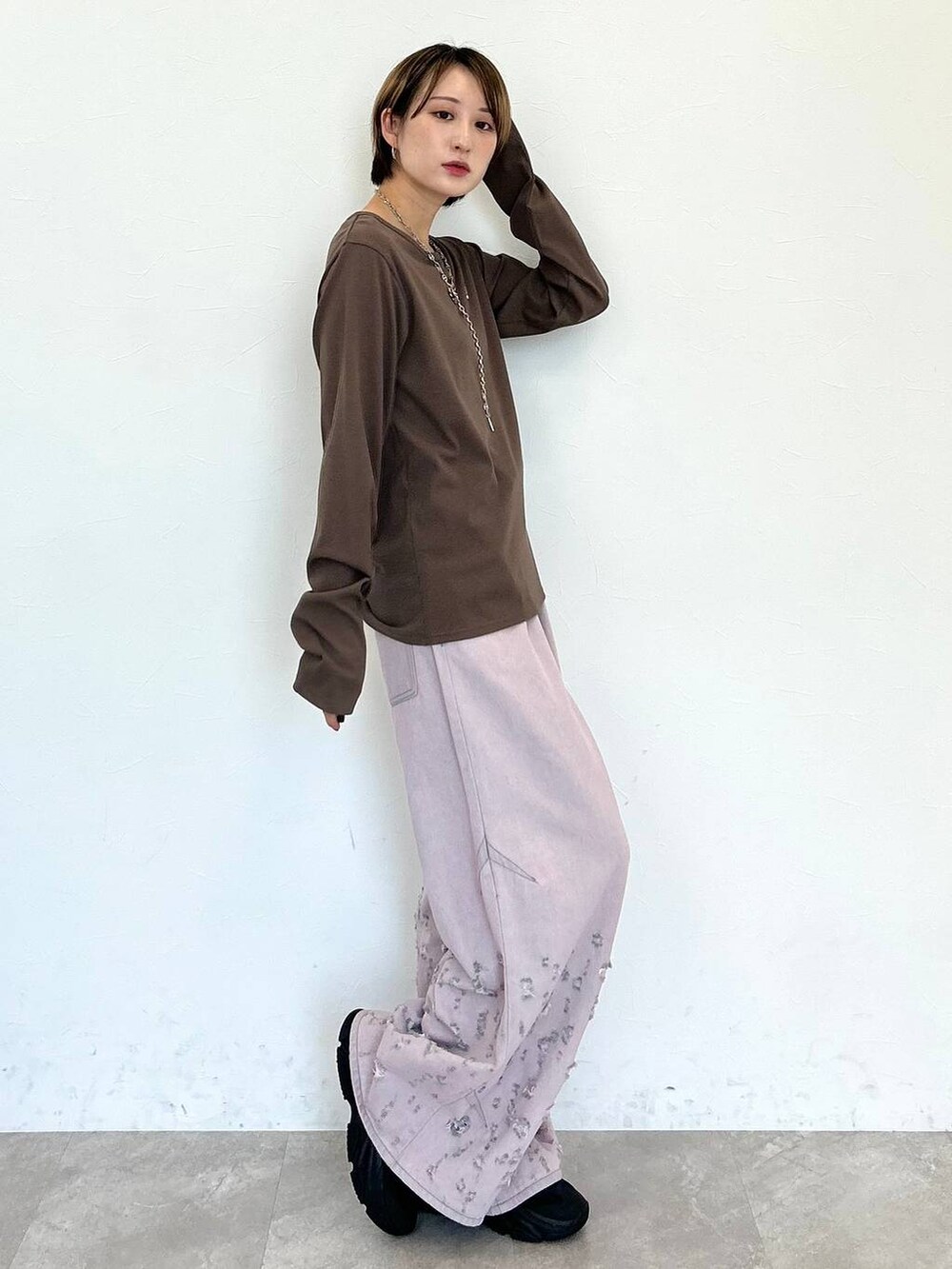 ピンク系のデニムパンツ、ブラウン系のTシャツ/カットソー、シルバー系のネックレスを着用したレディースの秋コーディネートの5枚目の写真