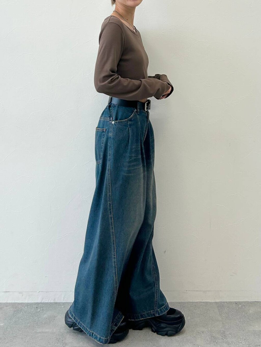 ブルー系のデニムパンツ、ブラック系のブーツ、ブラウン系のTシャツ/カットソーを着用したレディースの冬コーディネートの4枚目の写真