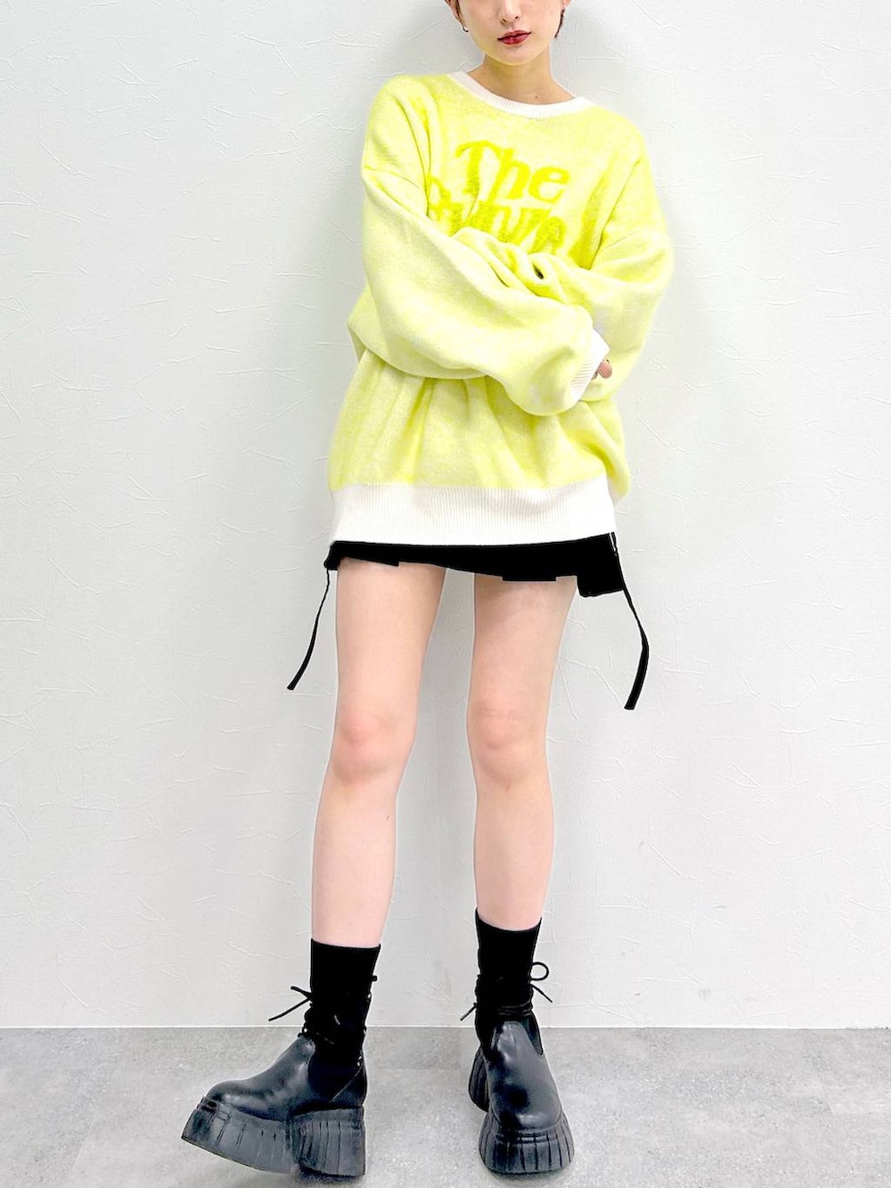 ホワイト系のニット/セーター、ブラック系のブーツ、ブラック系のスカートを着用したレディースの冬コーディネートの2枚目の写真