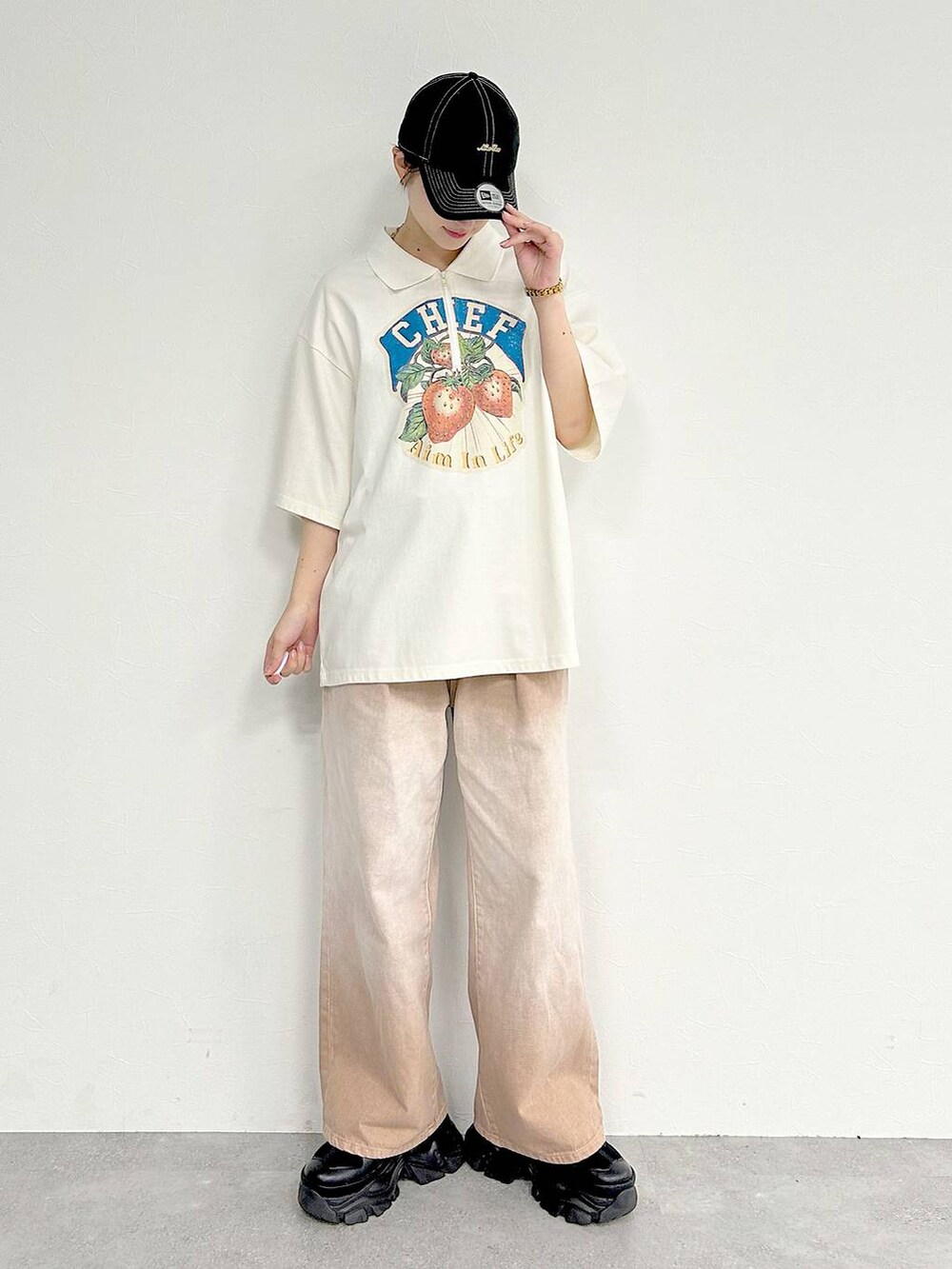 ピンク系のデニムパンツ、ブラック系のスニーカー、ホワイト系のTシャツ/カットソーを着用したレディースの夏コーディネートの2枚目の写真
