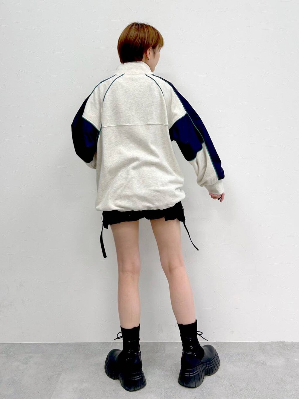 ブラック系のブーツ、ブラック系のスカート、ベージュ系のスウェットを着用したレディースの冬コーディネートの5枚目の写真