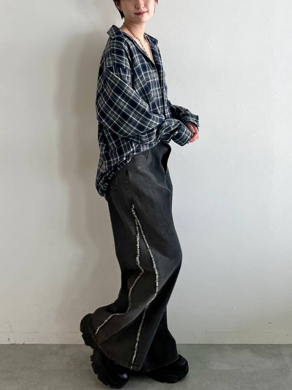 ブラック系のスニーカー、ブルー系のシャツ/ブラウス、ブラック系のデニムパンツを着用したレディースの秋コーディネートの4枚目の写真