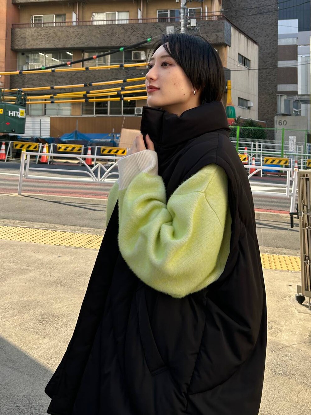 ブラック系のスラックス、ホワイト系のニット/セーター、ブラック系のブルゾンを着用したレディースの冬コーディネートの8枚目の写真