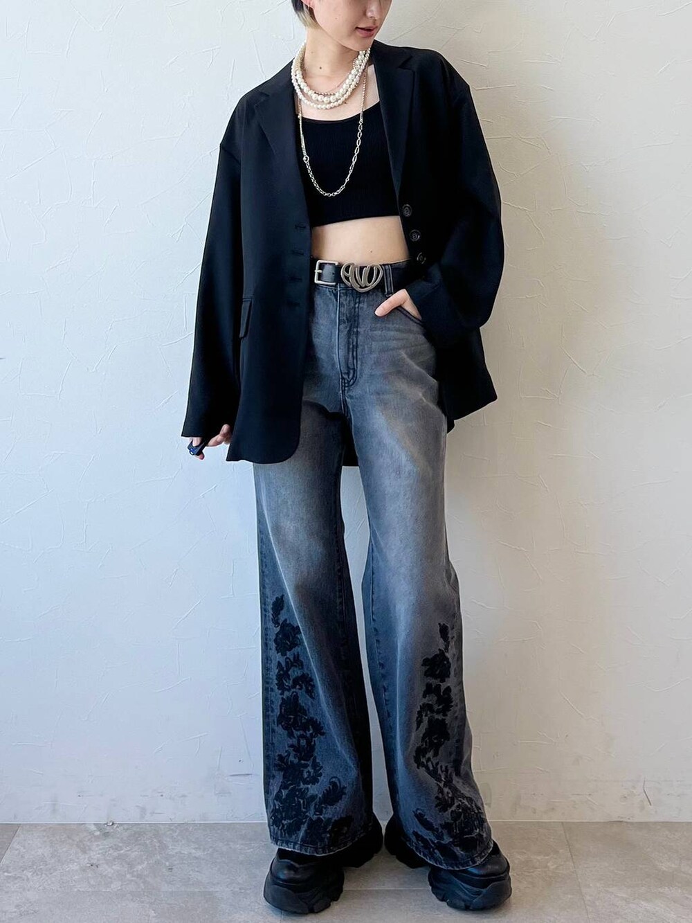 ブラック系のスニーカー、ブラック系のキャミソール、ブラック系のテーラードジャケットを着用したレディースの春コーディネートの2枚目の写真