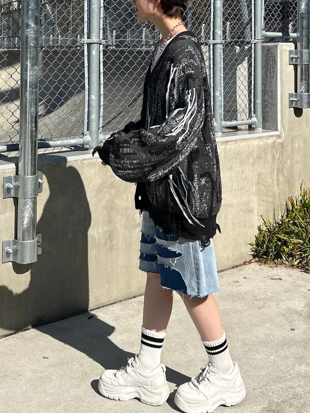 ホワイト系のTシャツ/カットソー、ブラック系のカーディガン/ボレロ、ブルー系のデニムパンツを着用したレディースの春コーディネートの4枚目の写真