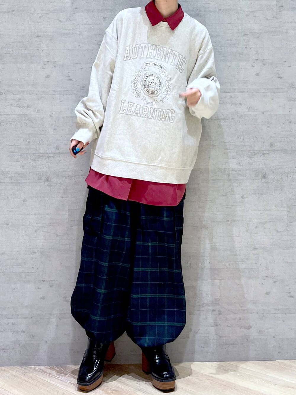 ベージュ系のスウェット、レッド系のシャツ/ブラウス、ブルー系のカーゴパンツを着用したレディースの冬コーディネートの2枚目の写真