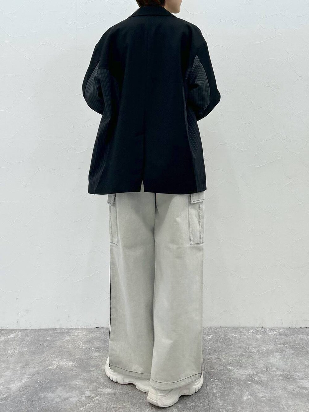 ブラック系のテーラードジャケット、ホワイト系のデニムパンツ、ブラック系のTシャツ/カットソーを着用したレディースの春コーディネートの7枚目の写真