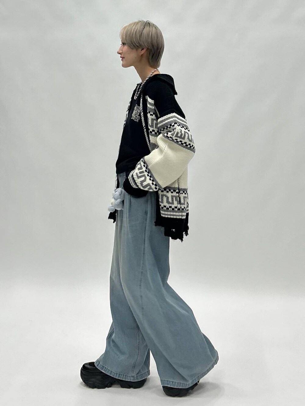 ブルー系のデニムパンツ、ブラック系のブーツ、ブラック系のスウェットを着用したレディースの秋コーディネートの4枚目の写真