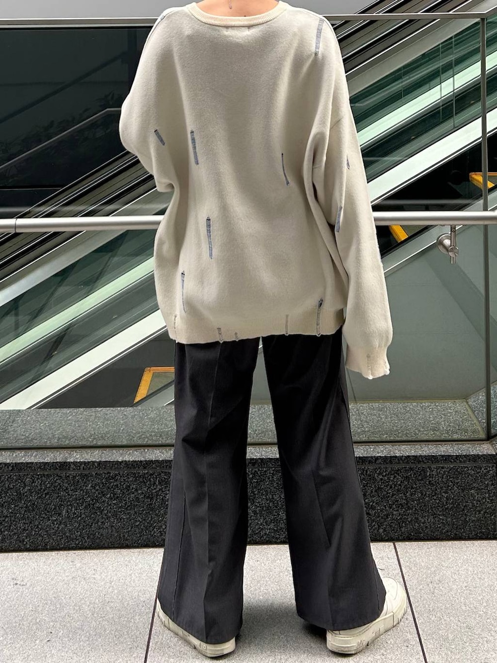 グレー系のスラックス、ホワイト系のニット/セーターを着用したレディースの冬コーディネートの6枚目の写真