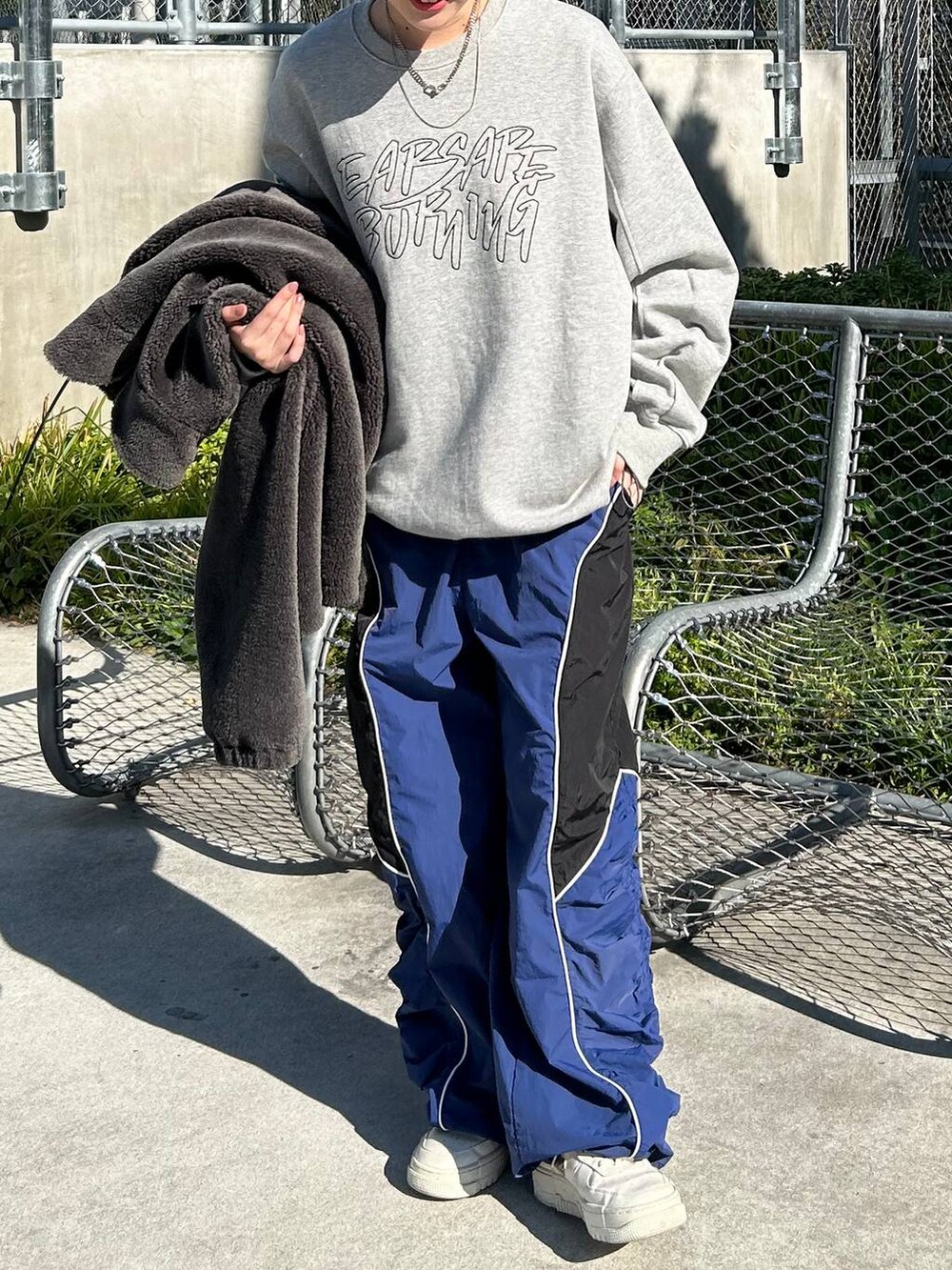 グレー系のその他アウター、グレー系のスウェット、ブルー系のその他パンツを着用したレディースの冬コーディネートの2枚目の写真