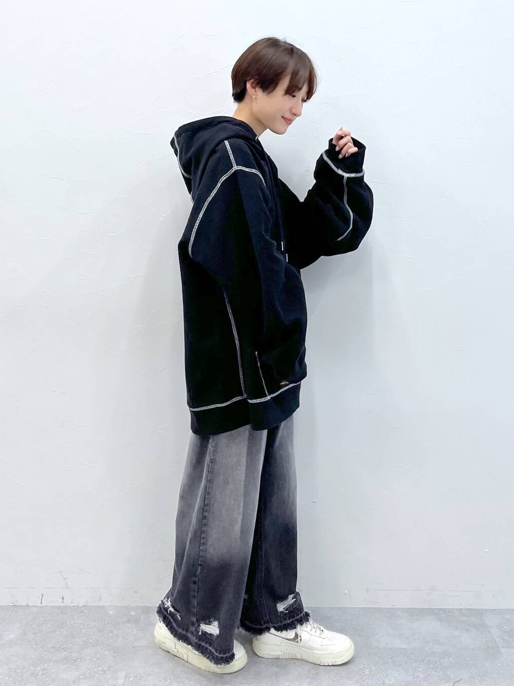 ブラック系のデニムパンツ、ブラック系のパーカーを着用したレディースの秋コーディネートの4枚目の写真
