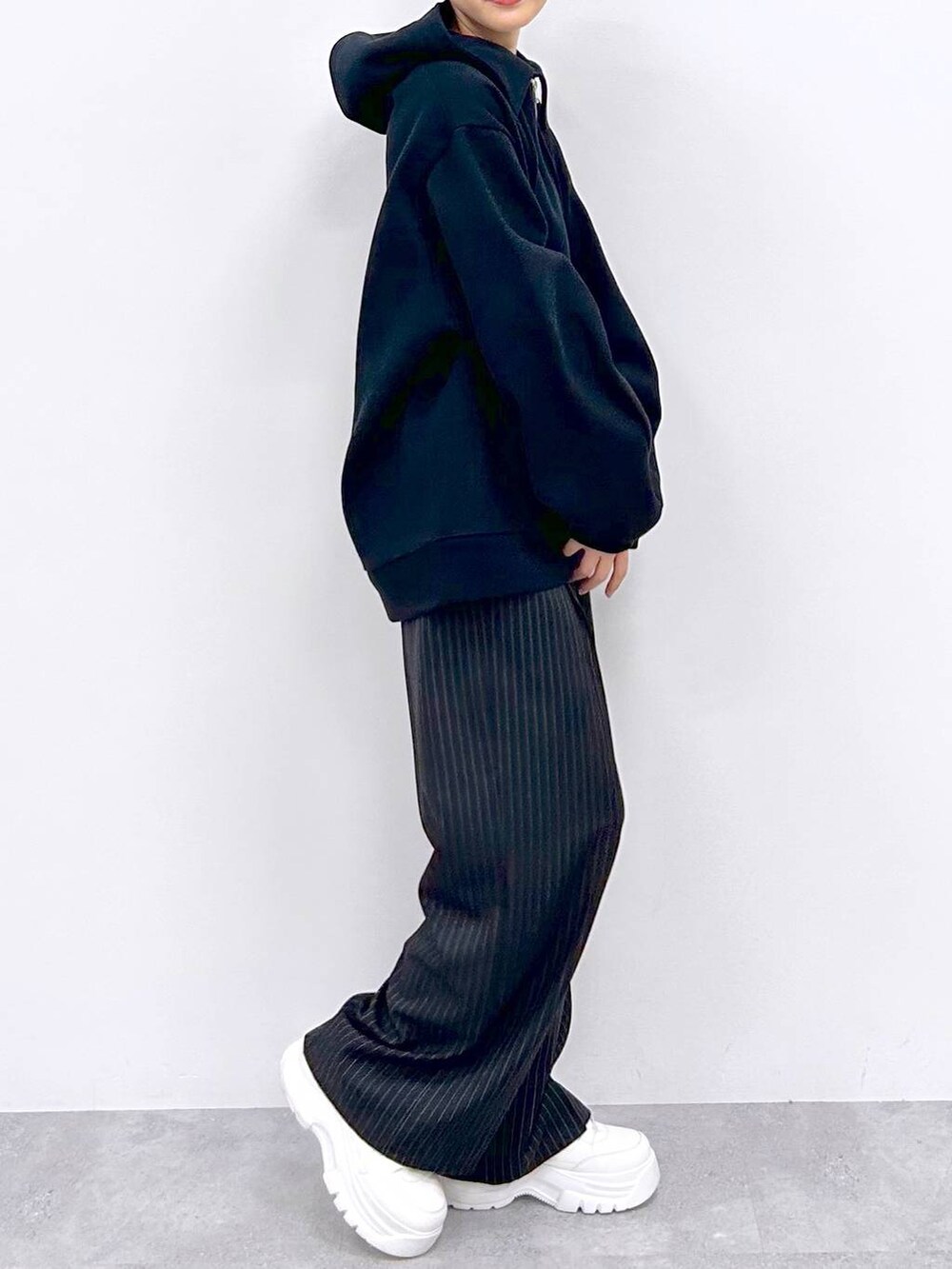 ブラック系のスラックス、ブラック系のパーカーを着用したレディースの秋コーディネートの5枚目の写真