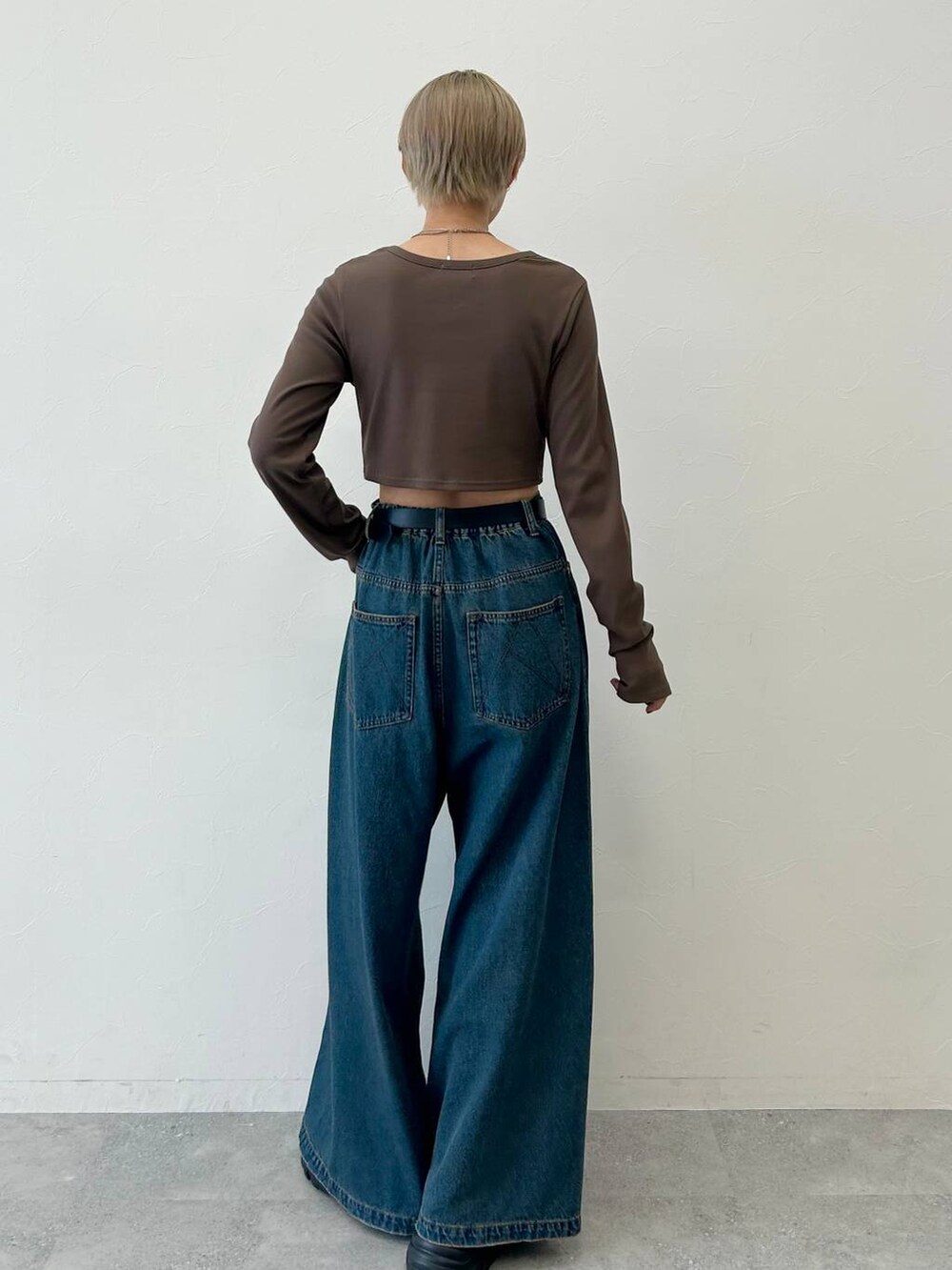 ブルー系のデニムパンツ、ブラック系のブーツ、ブラウン系のTシャツ/カットソーを着用したレディースの冬コーディネートの5枚目の写真