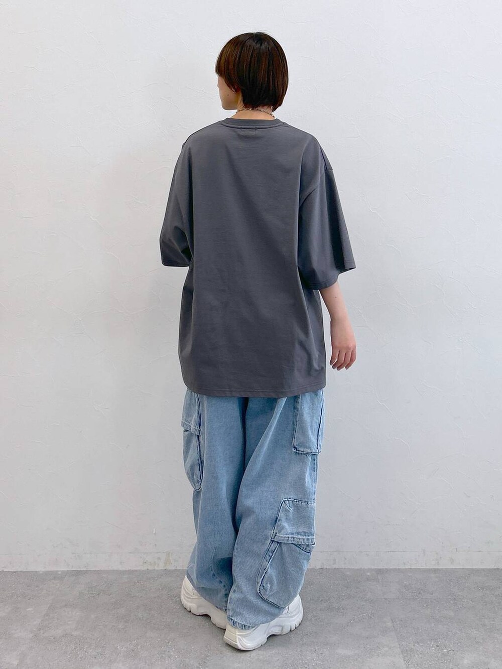 グレー系のTシャツ/カットソー、ブルー系のデニムパンツ、シルバー系のネックレスを着用したレディースの夏コーディネートの7枚目の写真