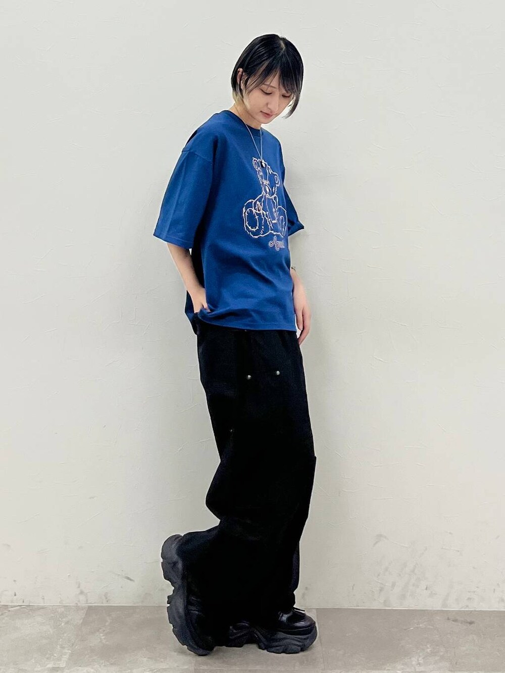 ブラック系のスニーカー、ブルー系のTシャツ/カットソー、ブラック系のカーゴパンツを着用したレディースの春コーディネートの4枚目の写真