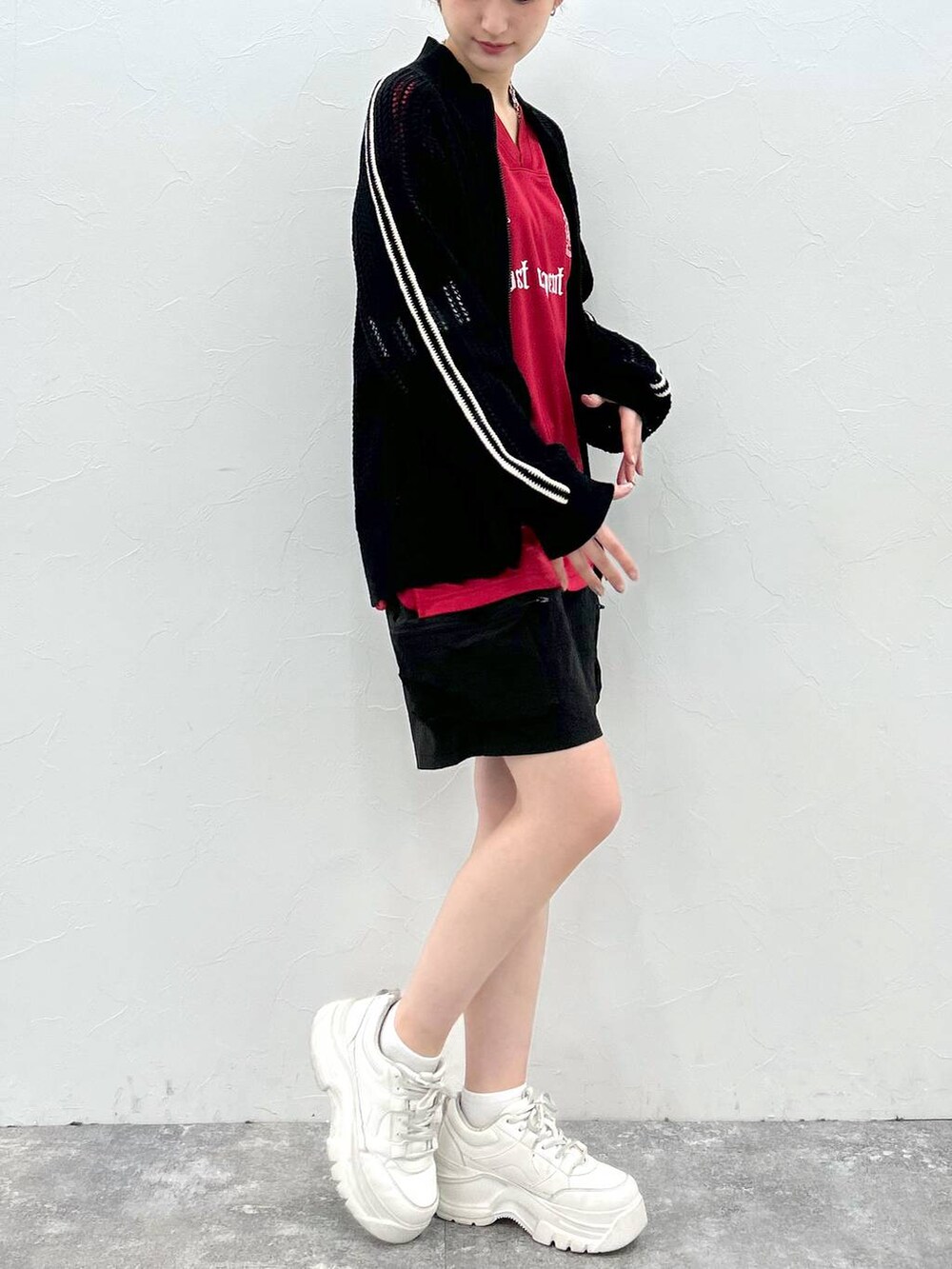 ブラック系のカーディガン/ボレロ、レッド系のTシャツ/カットソー、ブラック系のカーゴパンツを着用したレディースの春コーディネートの6枚目の写真