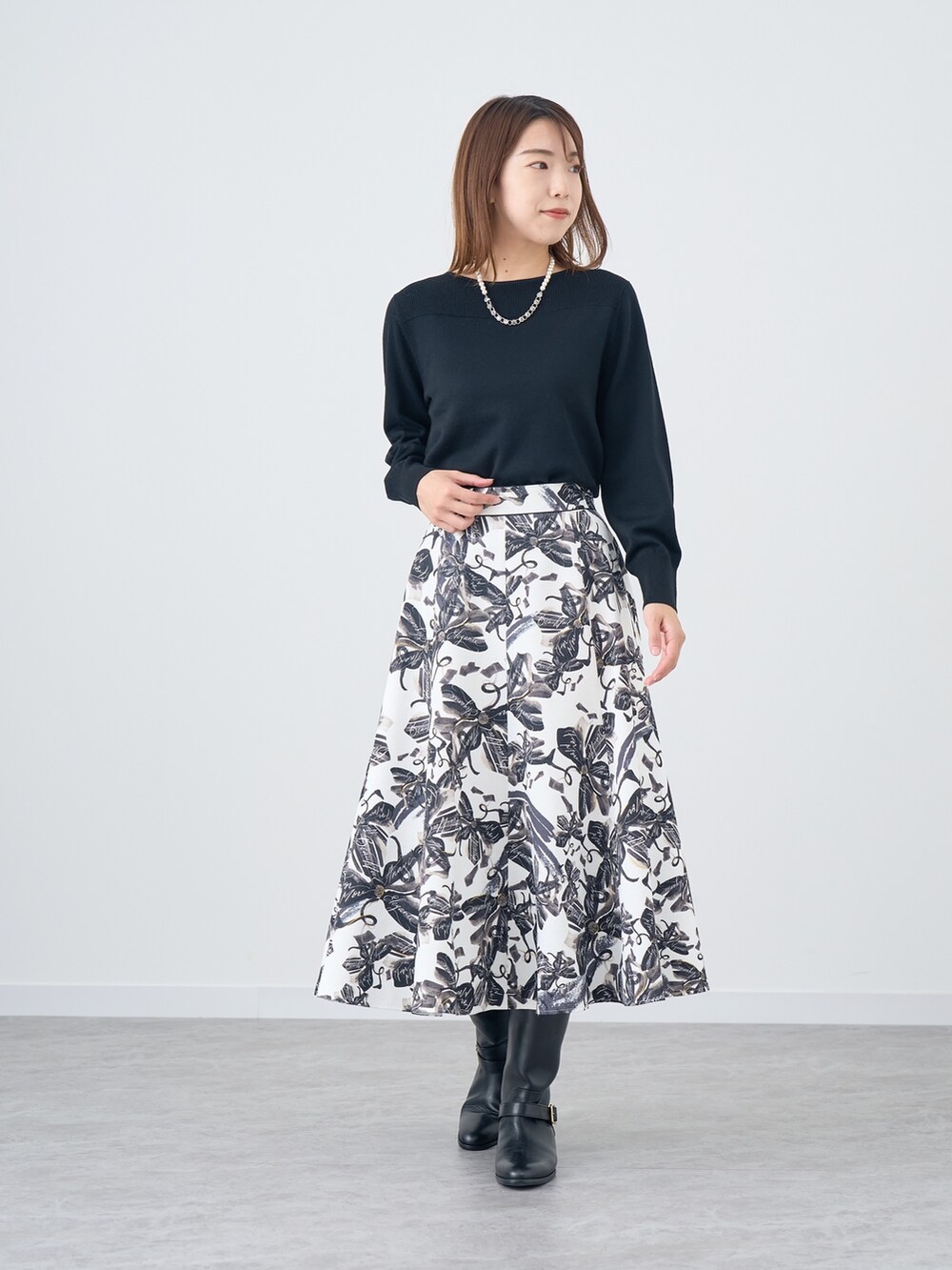 ホワイト系のスカート、ブラック系のニット/セーターを着用したレディースの秋コーディネートの2枚目の写真