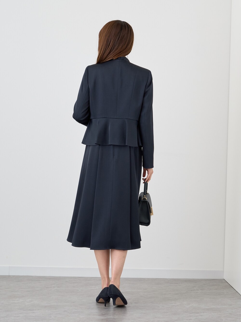 ブルー系のノーカラージャケット、ブルー系のワンピース、ブルー系のトートバッグを着用したレディースの秋コーディネートの2枚目の写真