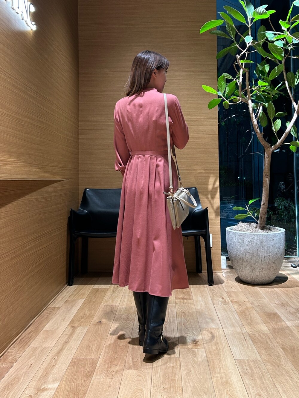 ピンク系のワンピース、ベージュ系のバックパック/リュックを着用したレディースの秋コーディネートの2枚目の写真